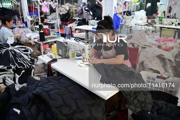 Workers are producing cotton clothing at a workshop in Liaocheng, China, on July 17, 2024. 