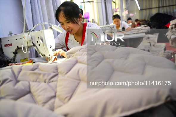 Workers are producing cotton clothing at a workshop in Liaocheng, China, on July 17, 2024. 