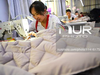 Workers are producing cotton clothing at a workshop in Liaocheng, China, on July 17, 2024. (