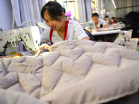 Workers are producing cotton clothing at a workshop in Liaocheng, China, on July 17, 2024. (