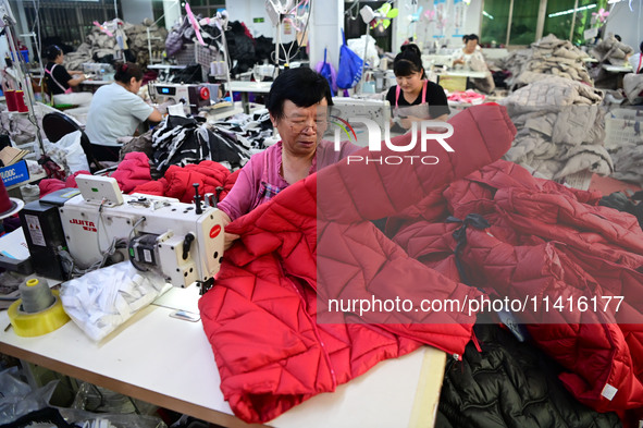 Workers are producing cotton clothing at a workshop in Liaocheng, China, on July 17, 2024. 