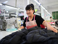 Workers are producing cotton clothing at a workshop in Liaocheng, China, on July 17, 2024. (