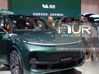 Visitors are looking at the 2024 Li Auto L9 electric car at the 21st Changchun International Automobile Expo in Changchun, Jilin province, C...