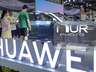 Spectators are looking at the Harmony OS AITO M9 electric car at the 21st Changchun International Automobile Expo in Changchun, Jilin provin...