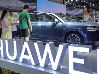 Spectators are looking at the Harmony OS AITO M9 electric car at the 21st Changchun International Automobile Expo in Changchun, Jilin provin...