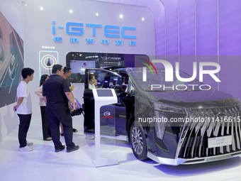 Visitors are looking at a GAC Trumpchi M8 electric car at the 21st Changchun International Automobile Expo in Changchun, Jilin province, Chi...