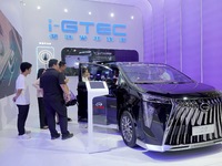 Visitors are looking at a GAC Trumpchi M8 electric car at the 21st Changchun International Automobile Expo in Changchun, Jilin province, Chi...