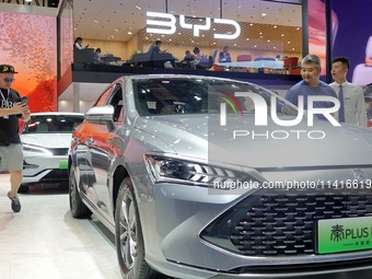 Spectators are viewing a BYD Qin PLUS DM-i electric car at the 21st Changchun International Automobile Expo in Changchun, Jilin province, Ch...