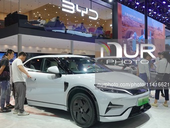 Spectators are looking at BYD Song L electric cars at the 21st Changchun International Automobile Expo in Changchun, Jilin province, China,...