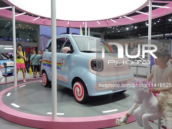 Visitors are looking at a FAW Pentium Pony electric car at the 21st Changchun International Automobile Expo in Changchun, Jilin province, Ch...