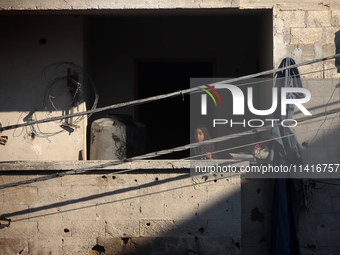 Palestinians are inspecting a house destroyed in an Israeli strike, amid the Israel-Hamas conflict, in Al-Zawaida, central Gaza Strip, on Ju...