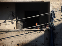 Palestinians are inspecting a house destroyed in an Israeli strike, amid the Israel-Hamas conflict, in Al-Zawaida, central Gaza Strip, on Ju...