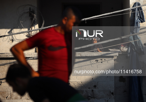 Palestinians are inspecting a house destroyed in an Israeli strike, amid the Israel-Hamas conflict, in Al-Zawaida, central Gaza Strip, on Ju...