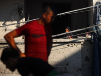 Palestinians are inspecting a house destroyed in an Israeli strike, amid the Israel-Hamas conflict, in Al-Zawaida, central Gaza Strip, on Ju...