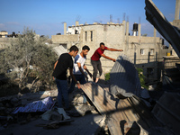 Palestinians are inspecting a house destroyed in an Israeli strike, amid the Israel-Hamas conflict, in Al-Zawaida, central Gaza Strip, on Ju...