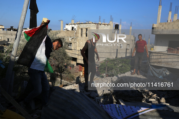 Palestinians are inspecting a house destroyed in an Israeli strike, amid the Israel-Hamas conflict, in Al-Zawaida, central Gaza Strip, on Ju...