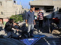 Palestinians are inspecting a house destroyed in an Israeli strike, amid the Israel-Hamas conflict, in Al-Zawaida, central Gaza Strip, on Ju...