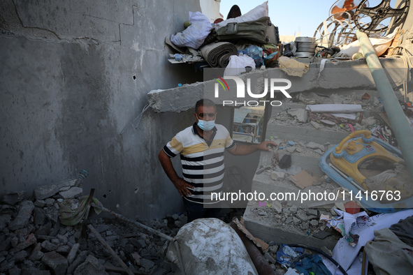 Palestinians are inspecting a house destroyed in an Israeli strike, amid the Israel-Hamas conflict, in Al-Zawaida, central Gaza Strip, on Ju...