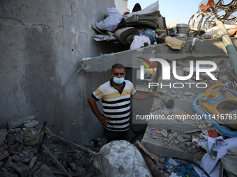 Palestinians are inspecting a house destroyed in an Israeli strike, amid the Israel-Hamas conflict, in Al-Zawaida, central Gaza Strip, on Ju...