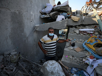 Palestinians are inspecting a house destroyed in an Israeli strike, amid the Israel-Hamas conflict, in Al-Zawaida, central Gaza Strip, on Ju...