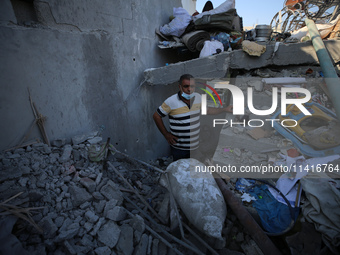 Palestinians are inspecting a house destroyed in an Israeli strike, amid the Israel-Hamas conflict, in Al-Zawaida, central Gaza Strip, on Ju...