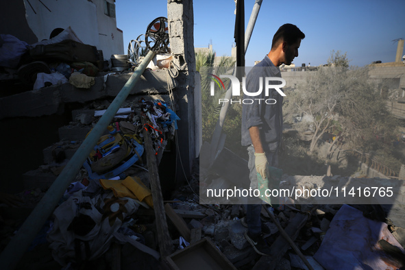 Palestinians are inspecting a house destroyed in an Israeli strike, amid the Israel-Hamas conflict, in Al-Zawaida, central Gaza Strip, on Ju...