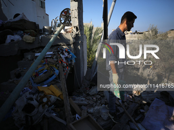 Palestinians are inspecting a house destroyed in an Israeli strike, amid the Israel-Hamas conflict, in Al-Zawaida, central Gaza Strip, on Ju...