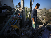 Palestinians are inspecting a house destroyed in an Israeli strike, amid the Israel-Hamas conflict, in Al-Zawaida, central Gaza Strip, on Ju...