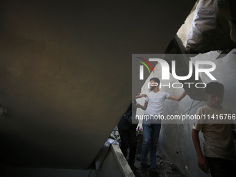 Palestinians are inspecting a house destroyed in an Israeli strike, amid the Israel-Hamas conflict, in Al-Zawaida, central Gaza Strip, on Ju...