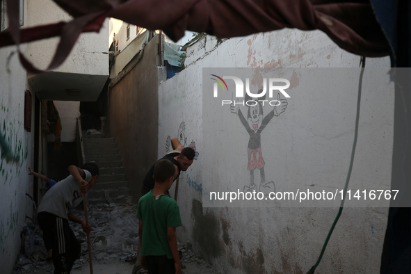 Palestinians are inspecting a house destroyed in an Israeli strike, amid the Israel-Hamas conflict, in Al-Zawaida, central Gaza Strip, on Ju...