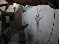 Palestinians are inspecting a house destroyed in an Israeli strike, amid the Israel-Hamas conflict, in Al-Zawaida, central Gaza Strip, on Ju...