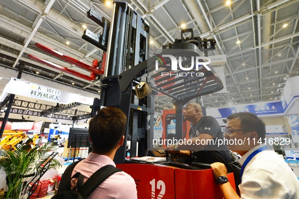 A technician is demonstrating a three-way stacker to a customer at the 26th China Qingdao International Industrial Automation Technology and...