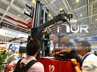 A technician is demonstrating a three-way stacker to a customer at the 26th China Qingdao International Industrial Automation Technology and...