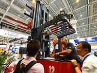 A technician is demonstrating a three-way stacker to a customer at the 26th China Qingdao International Industrial Automation Technology and...