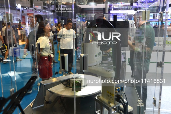 Participants are looking at an AI dynamic visual grasping unit display at the 26th China Qingdao International Industrial Automation Technol...