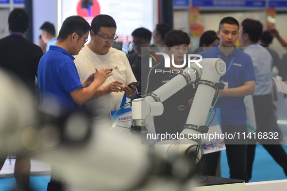 Participants are looking at a composite robot displayed by a company at the 26th China Qingdao International Industrial Automation Technolog...