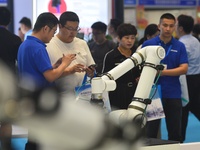 Participants are looking at a composite robot displayed by a company at the 26th China Qingdao International Industrial Automation Technolog...