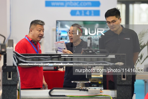 Participants are looking at a drive system displayed by a company at the 26th China Qingdao International Industrial Automation Technology a...