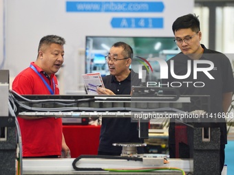 Participants are looking at a drive system displayed by a company at the 26th China Qingdao International Industrial Automation Technology a...