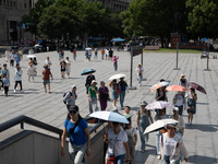 Tourists are using umbrellas to take a sightseeing tour at Chen Yi Square on the Bund in Huangpu district of Shanghai, China, on July 18, 20...