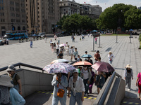 Tourists are using umbrellas to take a sightseeing tour at Chen Yi Square on the Bund in Huangpu district of Shanghai, China, on July 18, 20...