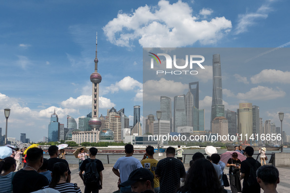 Tourists are using umbrellas to take a sightseeing tour on the Bund in Huangpu district in Shanghai, China, on July 18, 2024. 