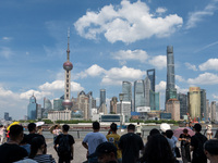 Tourists are using umbrellas to take a sightseeing tour on the Bund in Huangpu district in Shanghai, China, on July 18, 2024. (