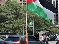 A woman is waving a large Palestinian flag during a Pro-Palestinian rally amid the Israel-Hamas conflict in Toronto, Ontario, Canada, on Jul...