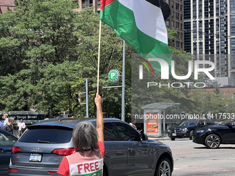 A woman is waving a large Palestinian flag during a Pro-Palestinian rally amid the Israel-Hamas conflict in Toronto, Ontario, Canada, on Jul...