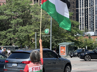 A woman is waving a large Palestinian flag during a Pro-Palestinian rally amid the Israel-Hamas conflict in Toronto, Ontario, Canada, on Jul...