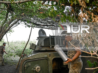 Andrii, a commander of an artillery crew of the 24th King Danylo Separate Mechanized Brigade, is using a handheld transceiver during a comba...