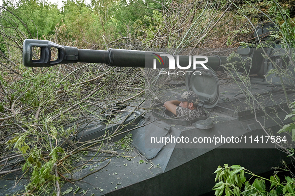 A serviceman of the 24th King Danylo Separate Mechanized Brigade is standing in the hatch of a military vehicle at combat positions near Cha...