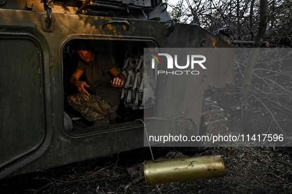 A serviceman of the 24th King Danylo Separate Mechanized Brigade is in the cabin of a 122-mm howitzer D-30 during a combat mission near Chas...