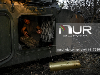 A serviceman of the 24th King Danylo Separate Mechanized Brigade is in the cabin of a 122-mm howitzer D-30 during a combat mission near Chas...